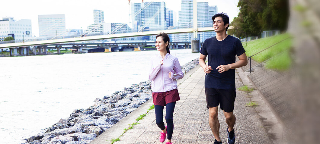 川辺でランニングを楽しむ男女の画像